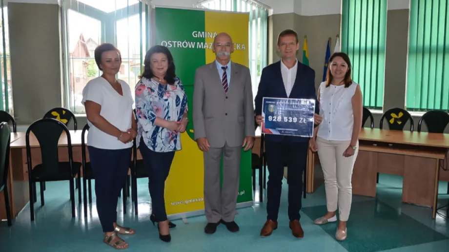 Starosta Ostrowski Zbigniew Chrupek wręczył na ręce wójta Gminy Ostrów Mazowiecka Waldemara Brzostka symboliczny czek o wartości 928 539,00 z